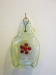 Flattened maple syrup bottle with flower design